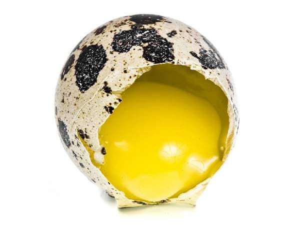Cracked quail egg with yolk