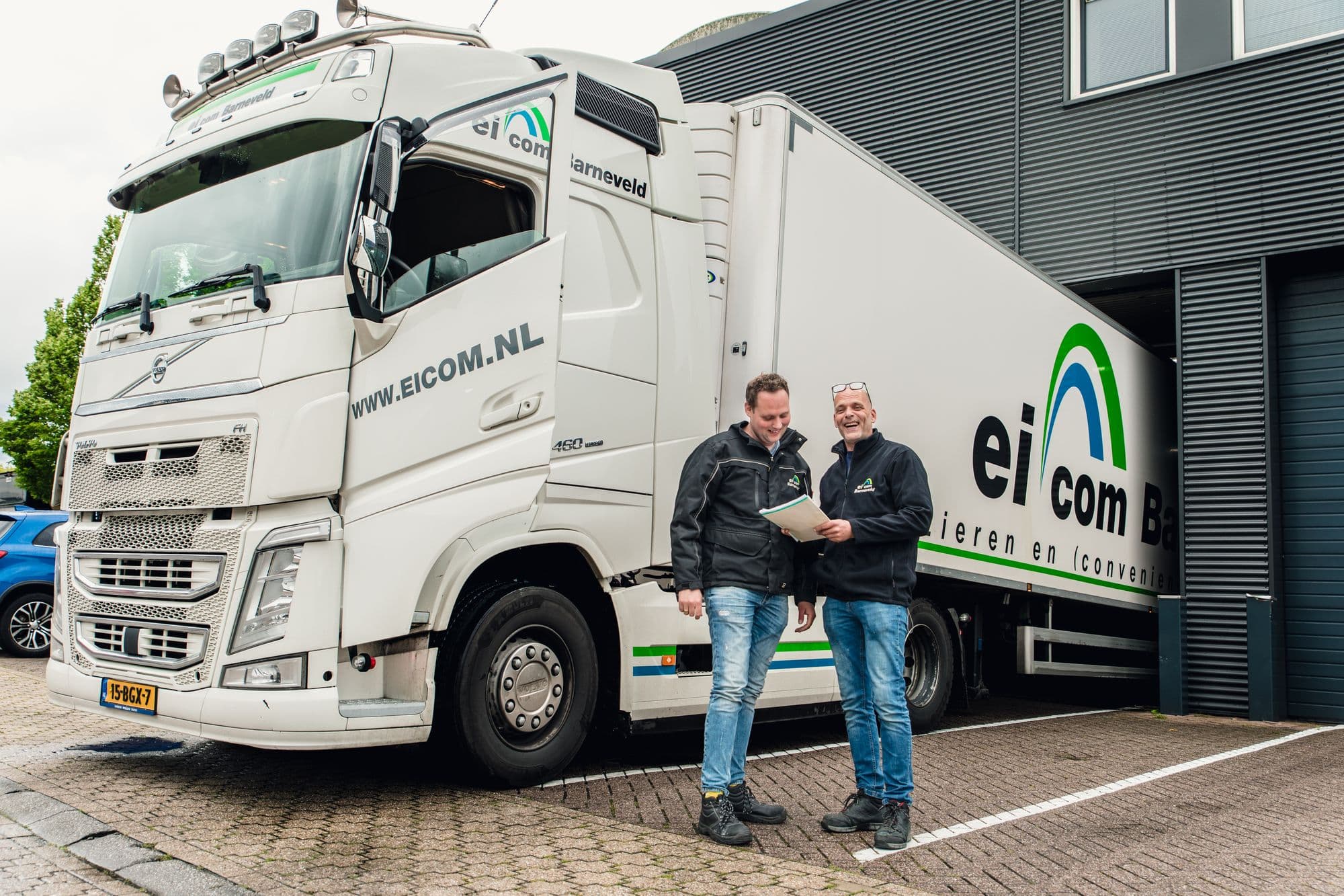 Twee collega's van Eicom Barneveld bij een vrachtwagen van Eicom Barneveld